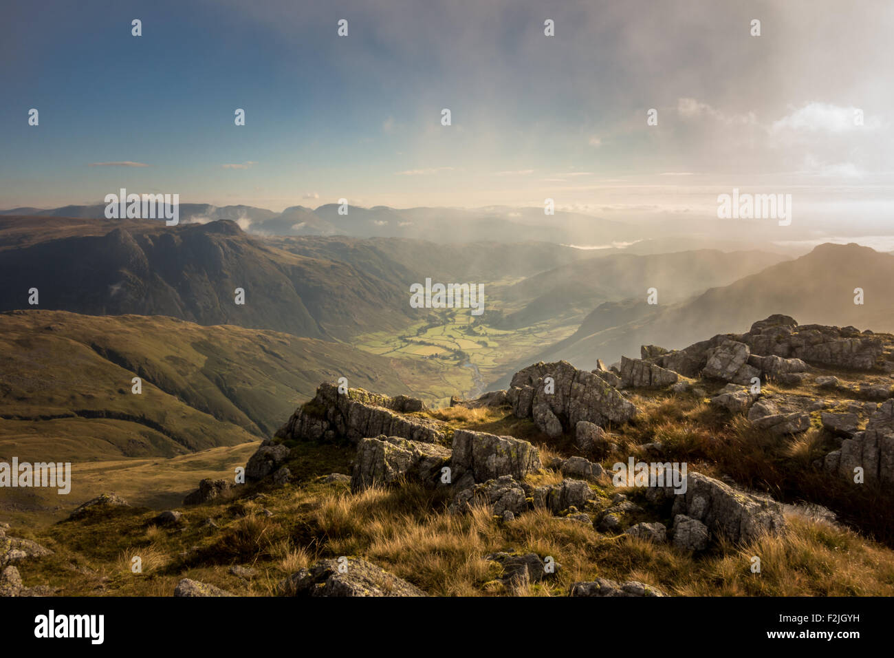 Guardando attraverso la nebbia in salita da Crinkle Crags down the Langdale valley, la mattina presto nel Lake District inglese Foto Stock