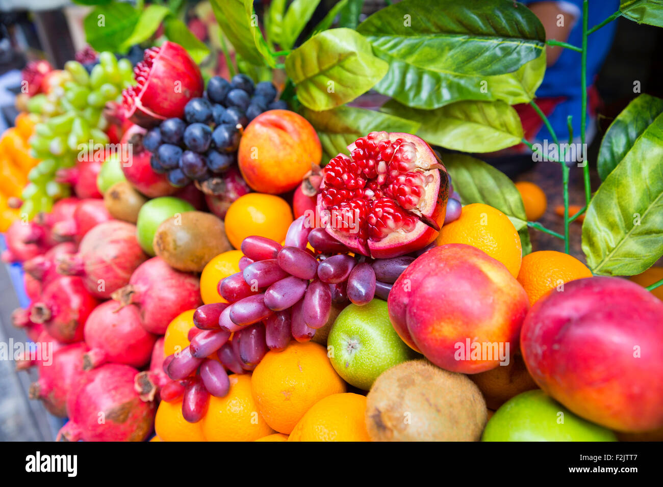 Molti tipi diversi di frutta in una vetrina. Venditore ambulante vendendo colorati frutti esotici e succo di frutta. Foto Stock
