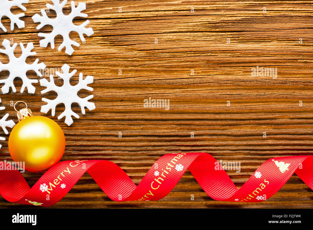 Sfondo di natale - Fiocchi e nastro rosso sul tavolo di legno Foto Stock