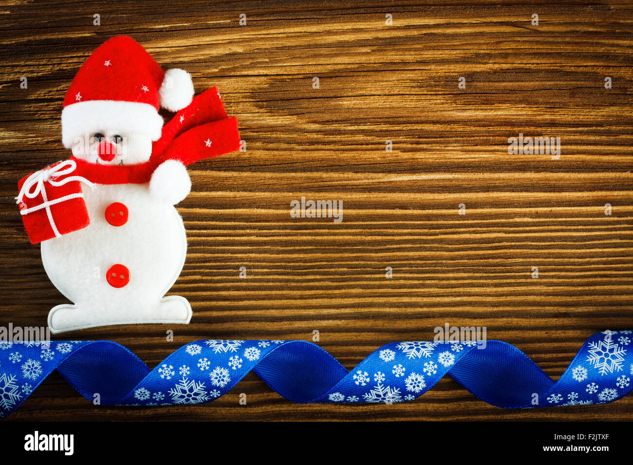 Sfondo di natale - pupazzo di neve e nastro di colore blu sul tavolo di legno Foto Stock