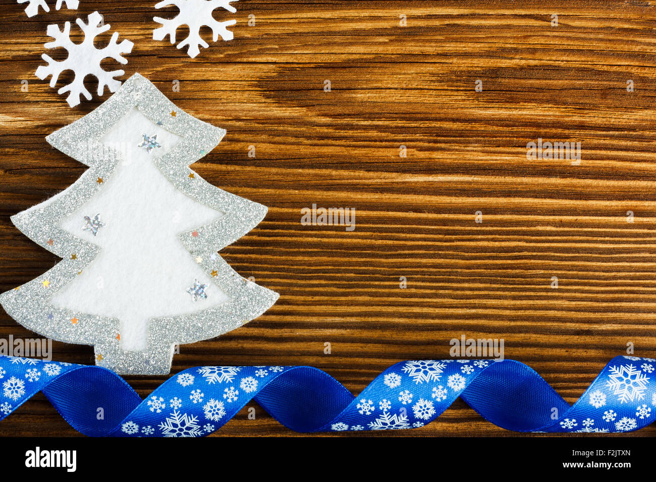 Sfondo di natale - fiocchi di neve, albero di natale e nastro di colore blu sul tavolo di legno Foto Stock