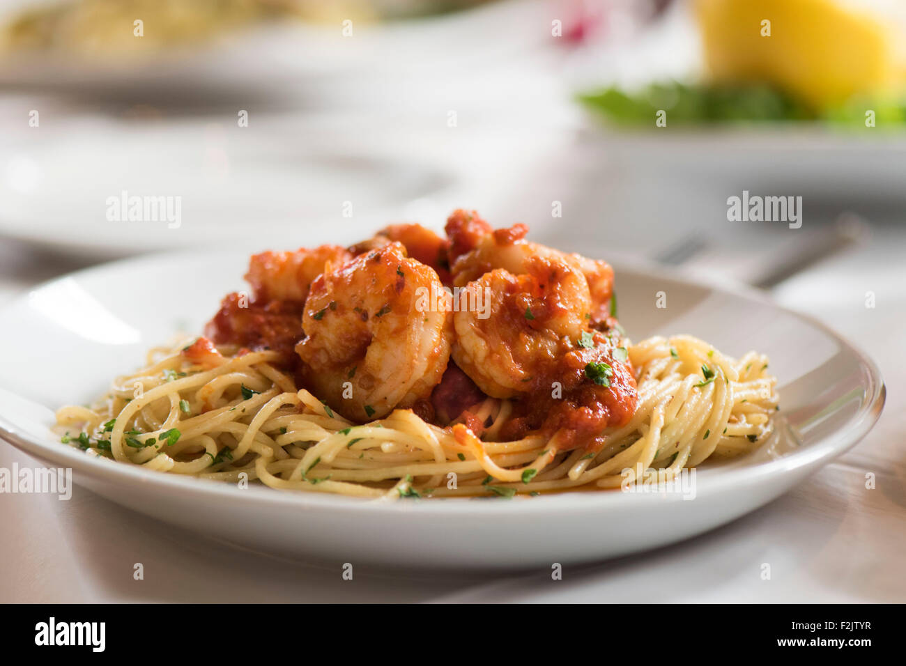 Pasto del re italiano i gamberi in salsa di pomodoro su spaghetti servita su piastra in un ristorante italiano. Foto Stock