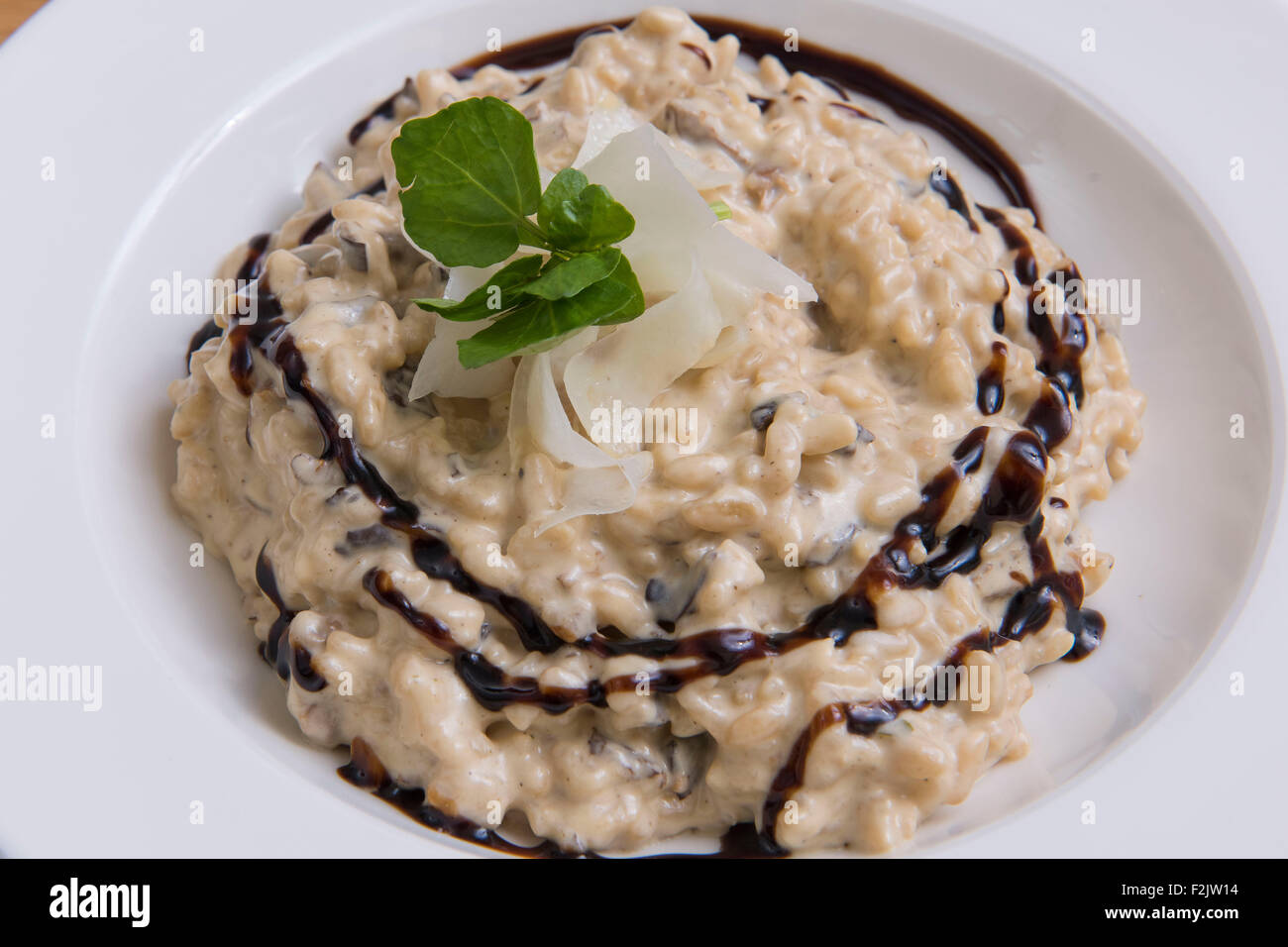 Un italiano di risotto ai funghi piatto pasto con glassa di aceto balsamico Foto Stock