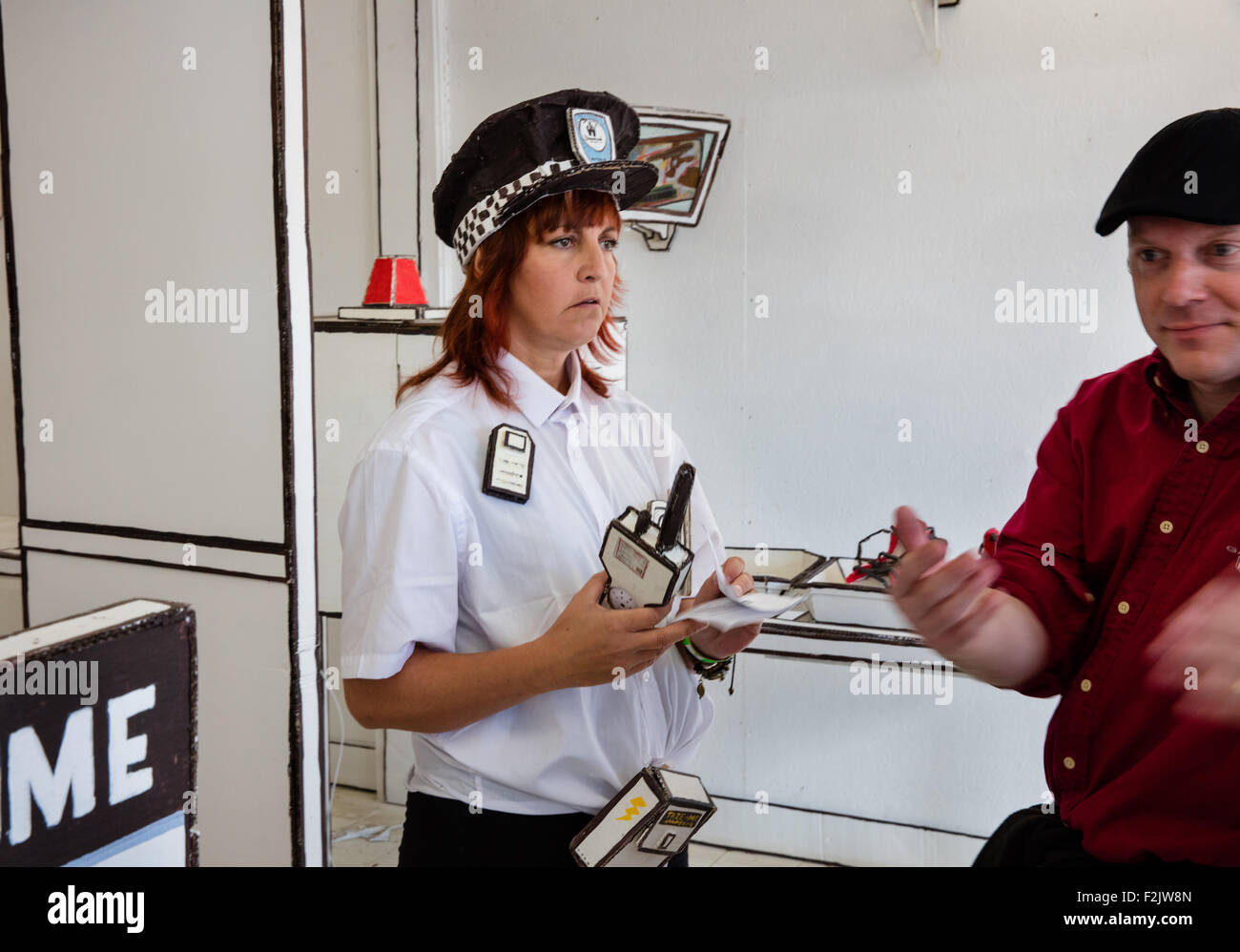 Una guardia di sicurezza allegramente accoglie un membro del pubblico a Dismaland - Banksy bemusement park in Weston super Mare Regno Unito Foto Stock