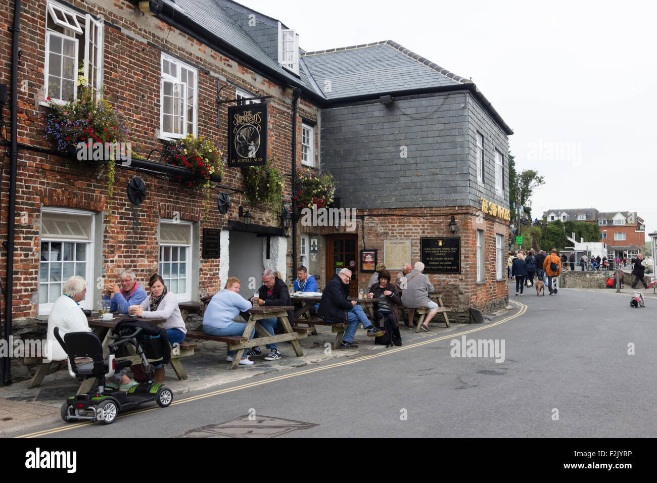 Villeggianti e turisti che si godono una metà di settembre ora di pranzo a The Shipwrights sul porto a Padstow, Cornwall Foto Stock