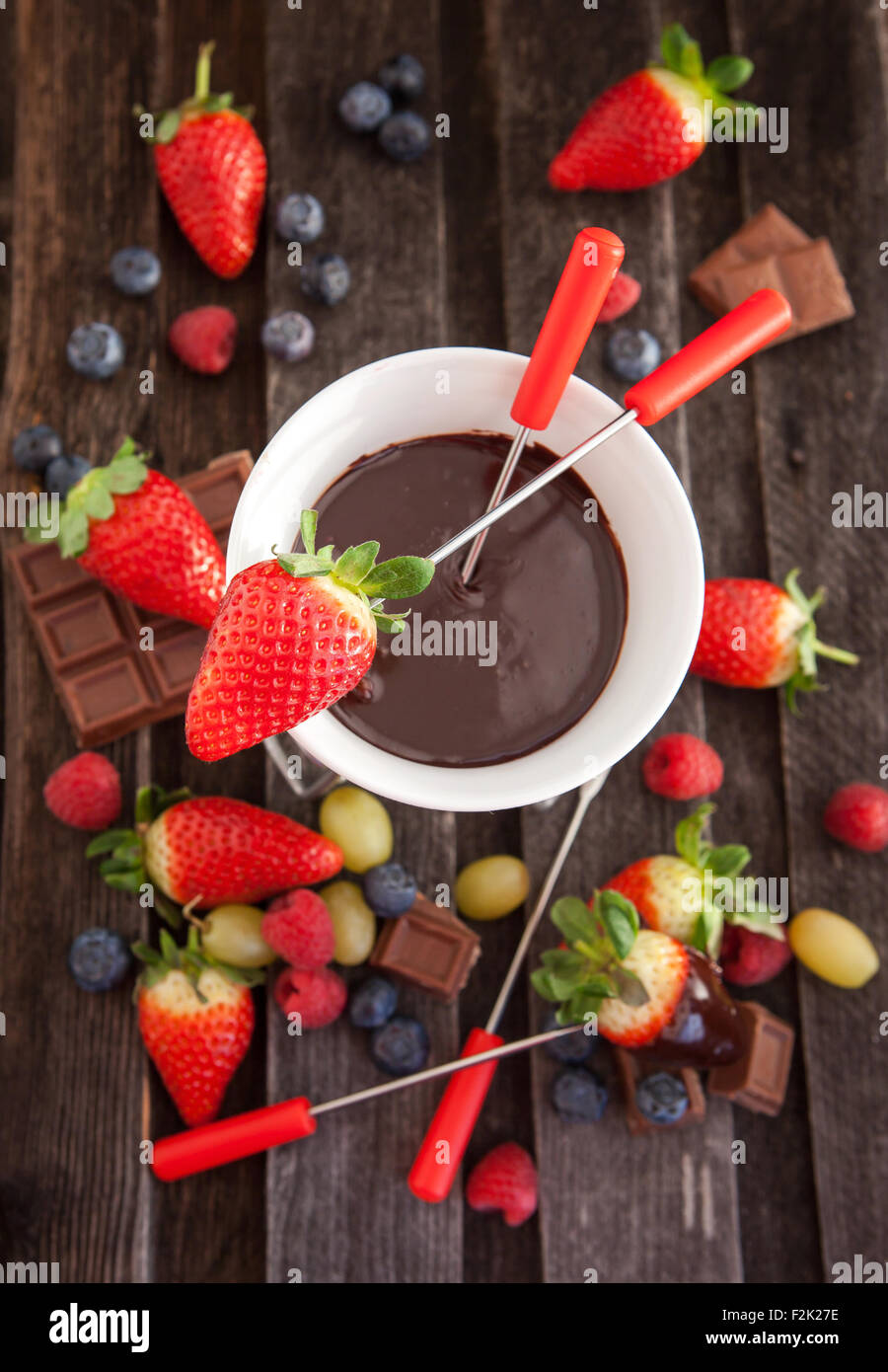 La Fonduta di cioccolato con frutti di bosco freschi sul tavolo di legno Foto Stock