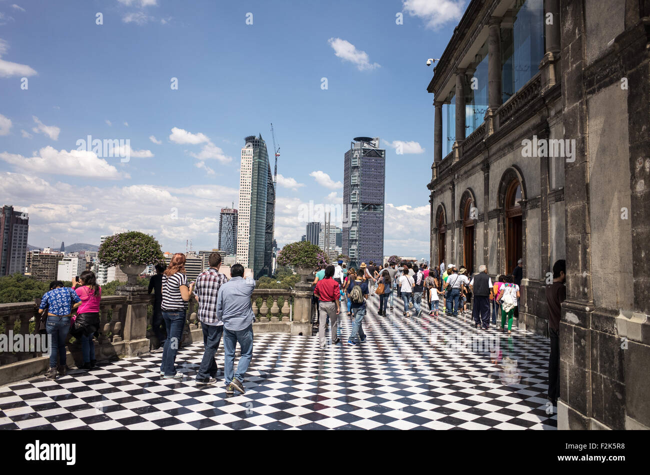 Chapultepec Castle Terrace città del Messico // CITTÀ DEL MESSICO, Messico — la terrazza nord del castello di Chapultepec presenta un caratteristico pavimento in marmo a scacchi bianco e nero che crea un suggestivo motivo geometrico attraverso lo spazio esterno sopraelevato. Questa terrazza, nota anche come loggia superiore, fa parte dell'ala residenziale del secondo piano del castello ed è supportata da sottili colonne che incorniciano il paesaggio circostante. Il design è stato creato durante la ristrutturazione del Alcázar da parte dell'imperatore Massimiliano negli anni '1860, combinando elementi architettonici neoclassici con uno spazio visivo funzionale. Foto Stock