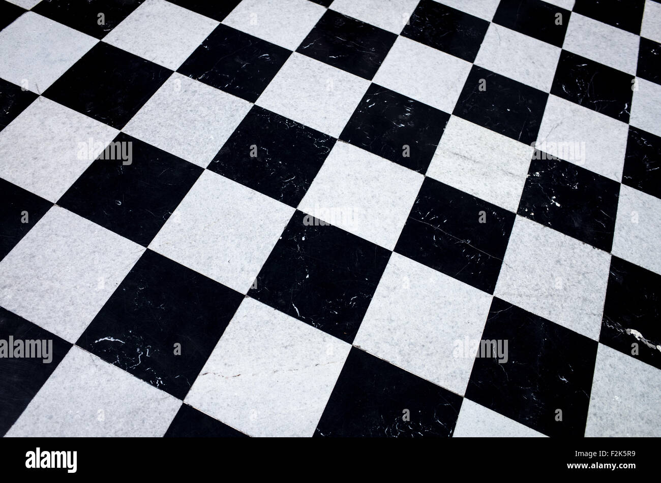 Castello di Chapultepec pavimento in marmo a scacchi città del Messico // CITTÀ DEL MESSICO, Messico - la terrazza nord del castello di Chapultepec presenta un caratteristico pavimento in marmo a scacchi bianco e nero che crea un suggestivo motivo geometrico attraverso lo spazio esterno sopraelevato. Questa terrazza, nota anche come loggia superiore, fa parte dell'ala residenziale del secondo piano del castello ed è supportata da sottili colonne che incorniciano il paesaggio circostante. Il progetto fu creato durante la ristrutturazione del Alcázar da parte dell'imperatore Massimiliano negli anni '1860, combinando elementi architettonici neoclassici con elementi funzionali Foto Stock