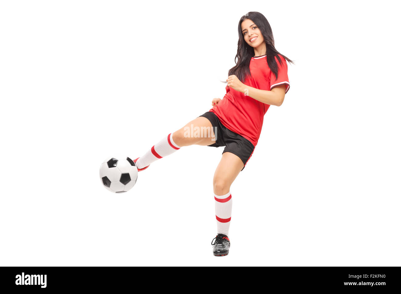 Allegro calcio femminile di tiro del giocatore una sfera e guardando la telecamera isolata su sfondo bianco Foto Stock