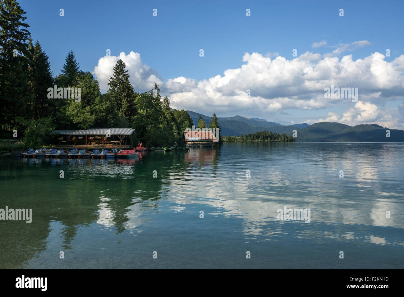 Il Boathouse sul Lago Walchensee, riflessi nell'acqua, nuvole a Einsiedl, Alta Baviera, Baviera, Germania Foto Stock