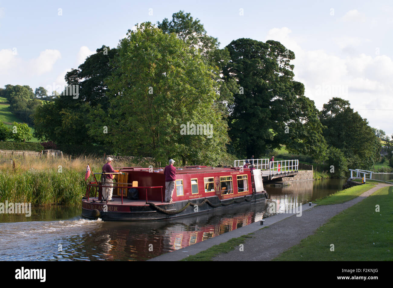 La Canal Boat adoperano passando Snaygill ponte girevole sul Leeds e Liverpool canal vicino a Skipton West Yorkshire Inghilterra, Regno Unito Foto Stock