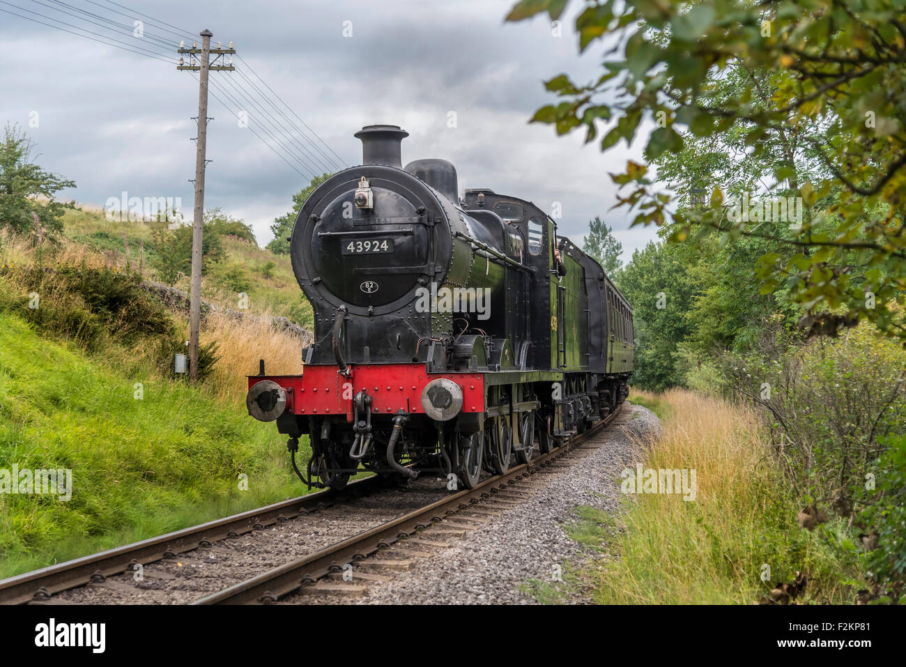 LMS/BR Classe 4F 0-6-0 "Big merci' motore trasporta un treno passeggeri a Haworth stazione sul Keighley e Worth Valley Railway. Foto Stock
