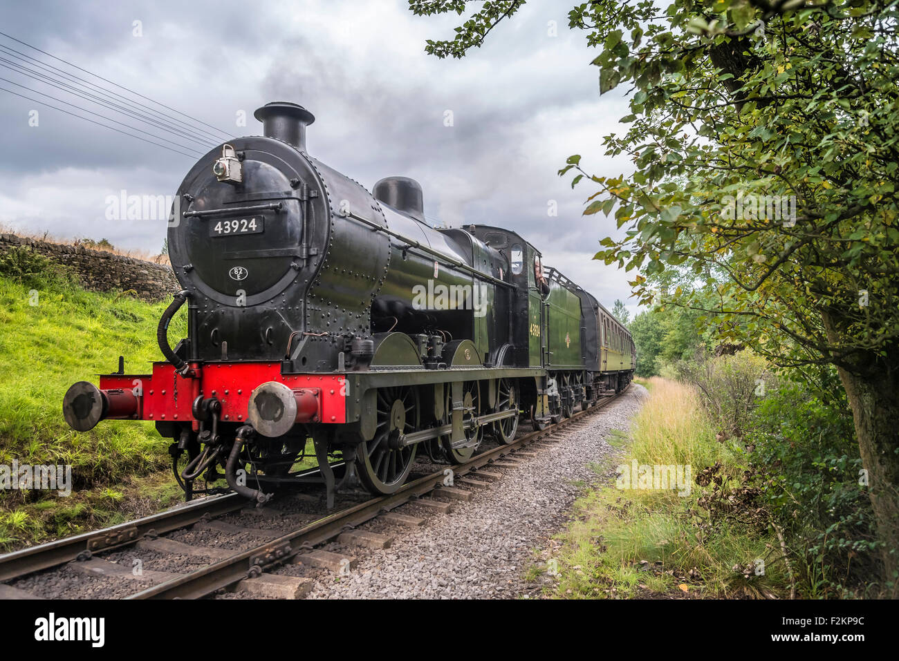 LMS/BR Classe 4F 0-6-0 "Big merci' motore trasporta un treno passeggeri a Haworth stazione sul Keighley e Worth Valley Railway. Foto Stock
