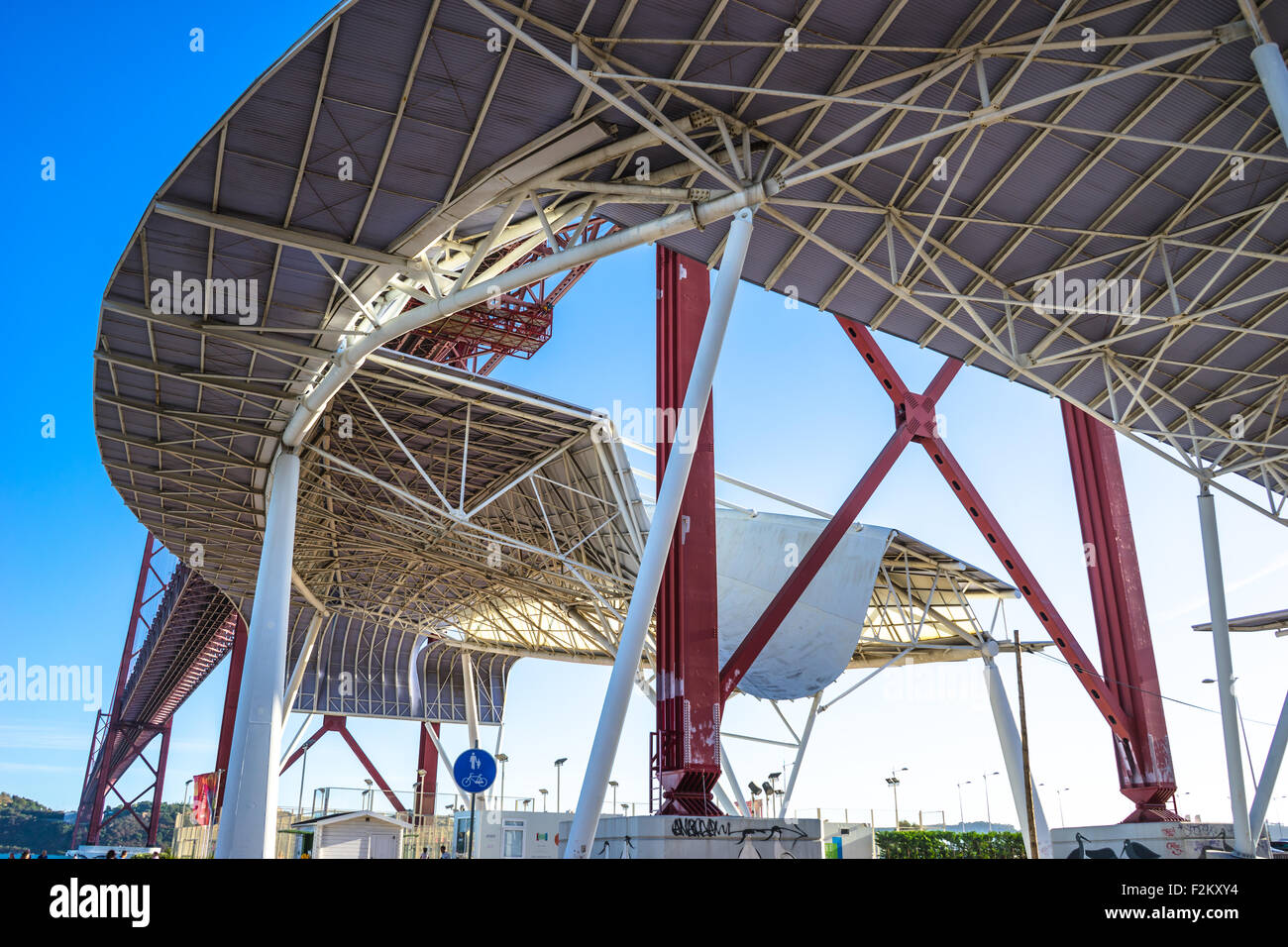 La luce del sole arte coperchio sotto il 25 de Abril Bridge a Lisbona, Portogallo. Foto Stock