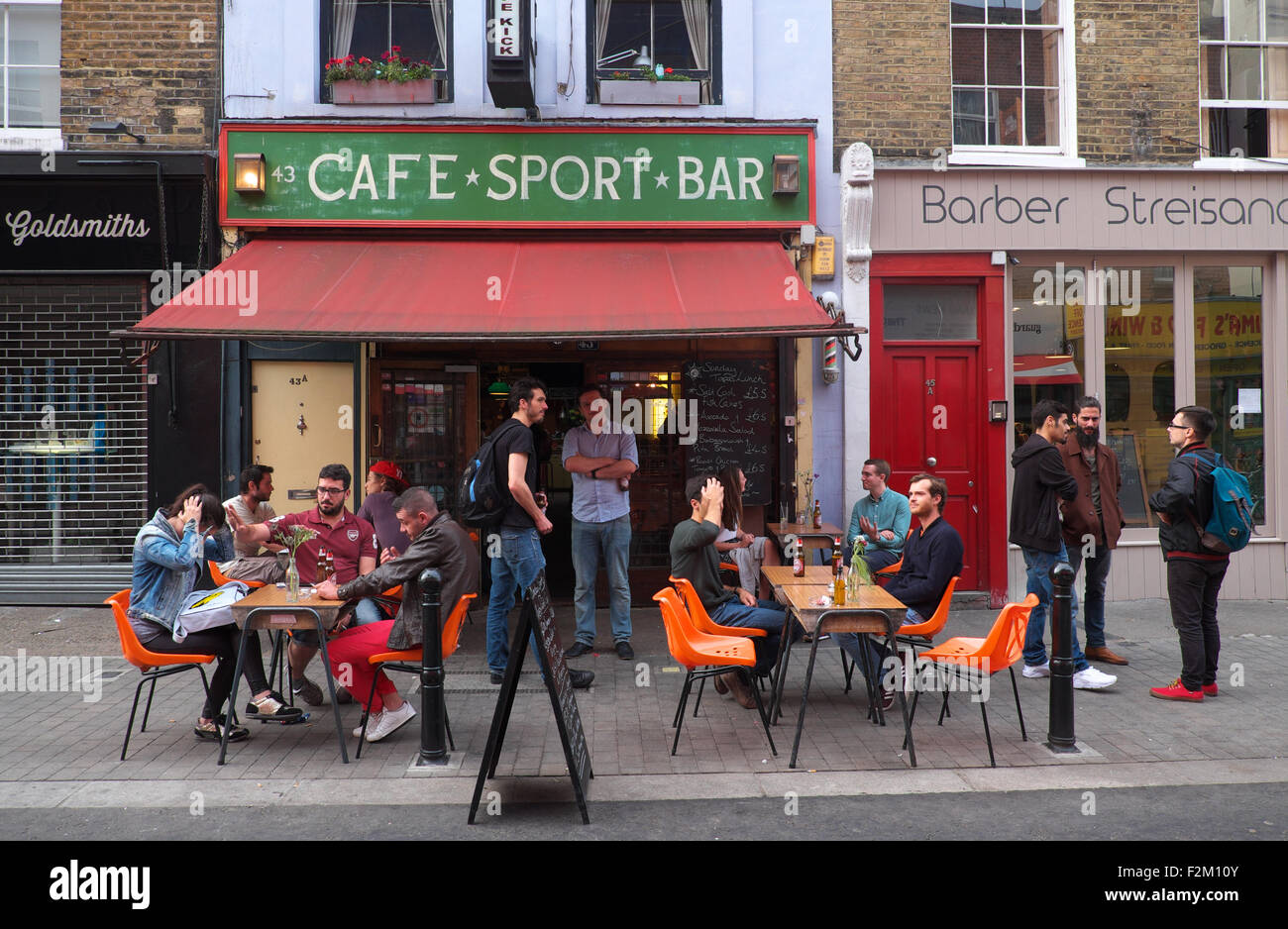 London street scene a Exmouth Market, Finsbury con clienti gustando un drink al di fuori del calcio cafe bar sport UK Foto Stock