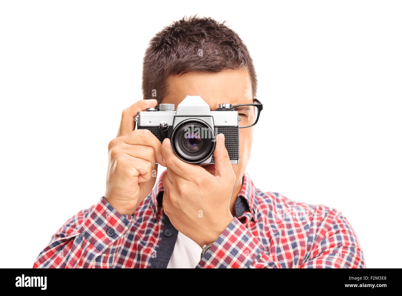 Studio shot di un giovane maschio fotografo di scattare una foto con una fotocamera isolati su sfondo bianco Foto Stock