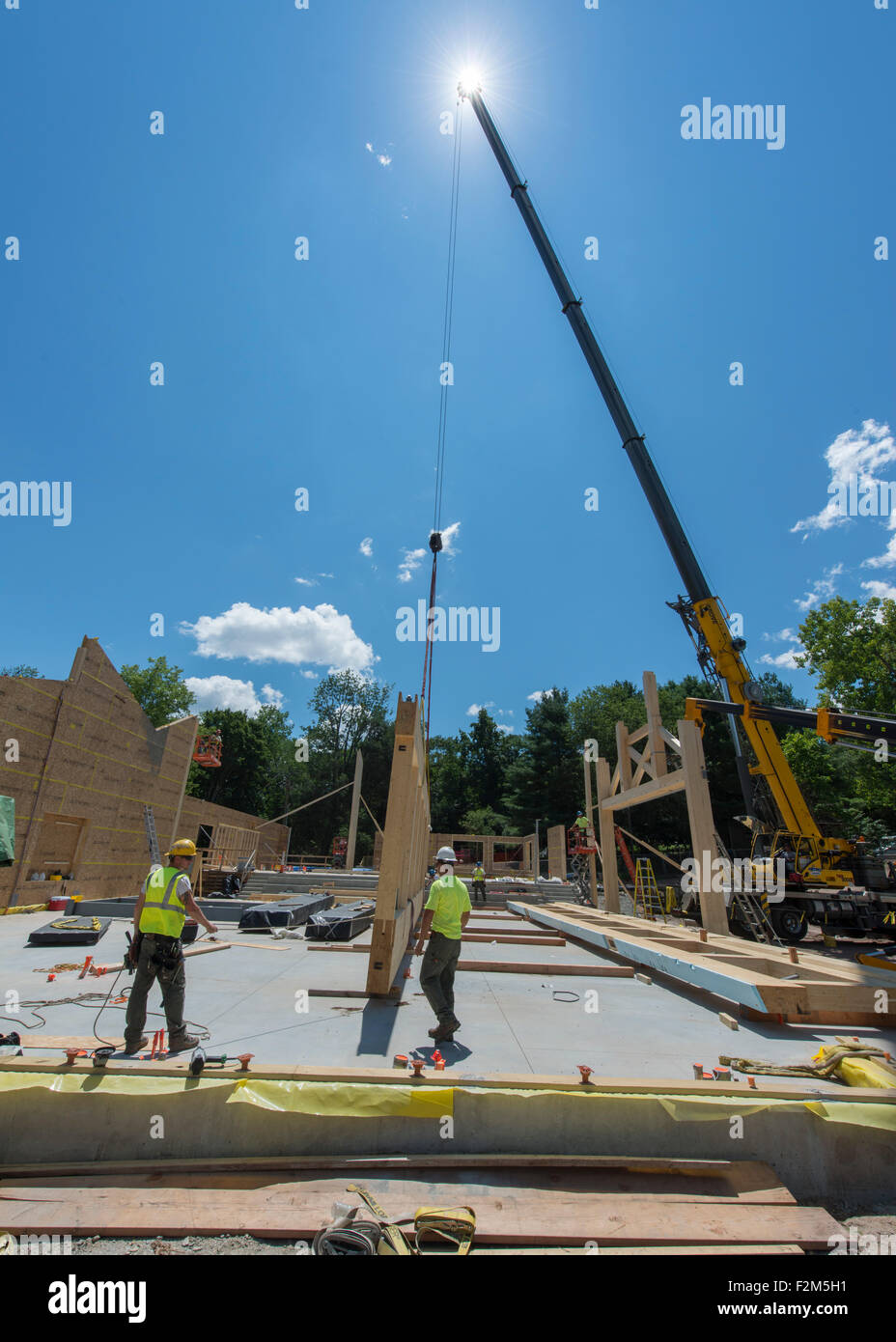 16.000 pound ingegnerizzati in legno travature in legno attendono l'installazione di gru per il Leed Platinum il terreno comune ad alto edificio scolastico. Foto Stock