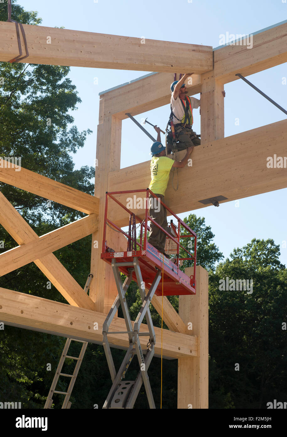 16.000 pound ingegnerizzati in legno travature in legno attendono l'installazione di gru per il Leed Platinum il terreno comune ad alto edificio scolastico. Foto Stock