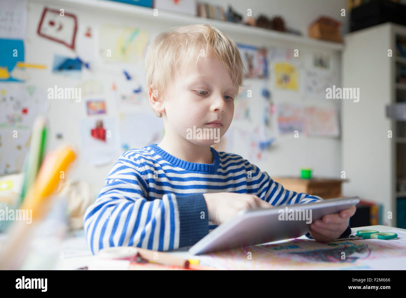 Ritratto di blonde little boy utilizzando tavoletta digitale Foto Stock