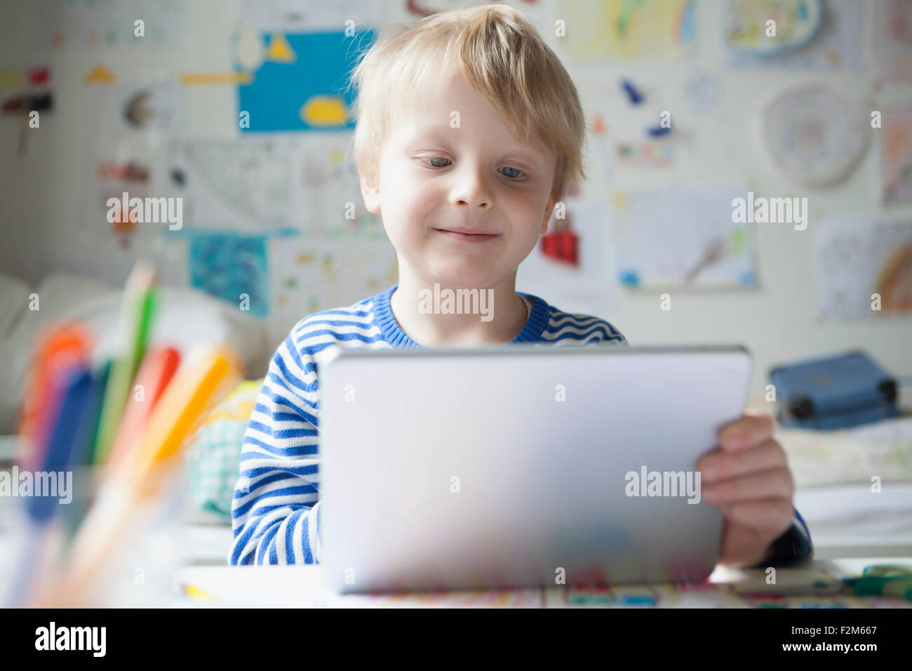 Ritratto di sorridere little boy utilizzando tavoletta digitale Foto Stock