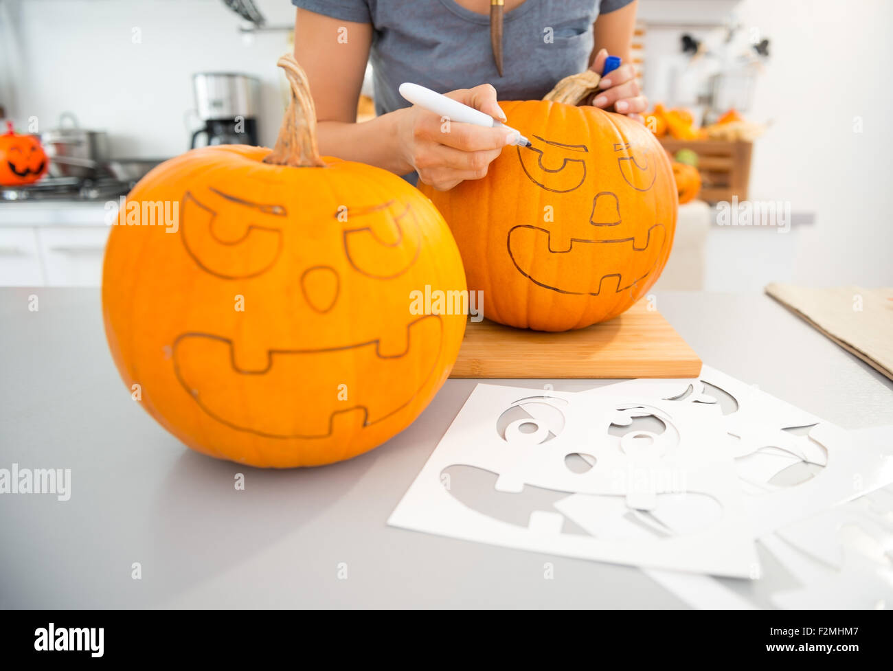 Chiudere fino sulla donna creazione di zucche Jack-O-Lantern per la festa di Halloween in cucina. Tradizionale autunno holiday Foto Stock