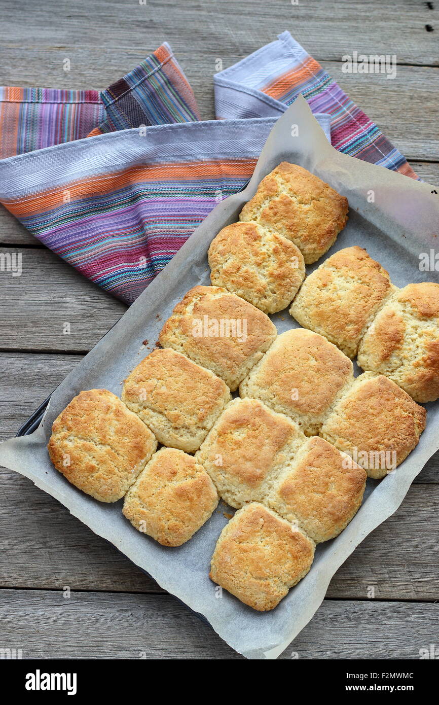 Pane appena sfornato focaccine fatte in casa in una teglia da forno su una tavola di legno Foto Stock