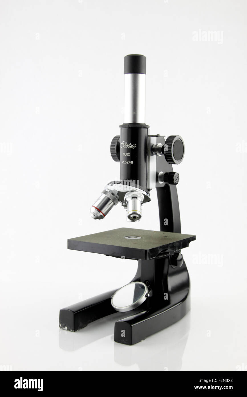 Un vecchio microscopio in aula isolata su una mentre lo sfondo. Foto Stock