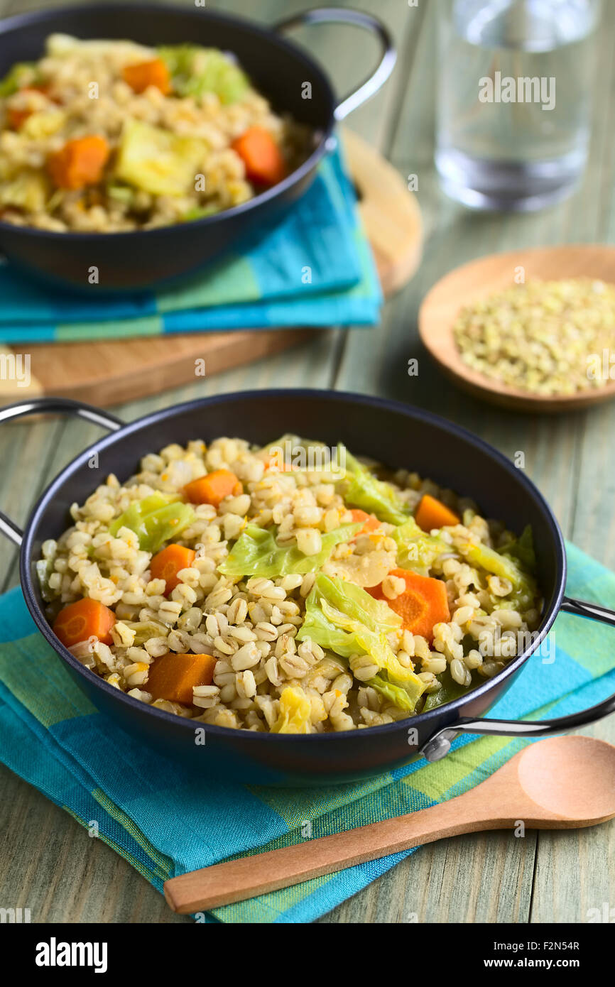 Stufato di vegano fatto di chicchi di grano, verze, carote, zucca e cipolla, fotografati con luce naturale Foto Stock