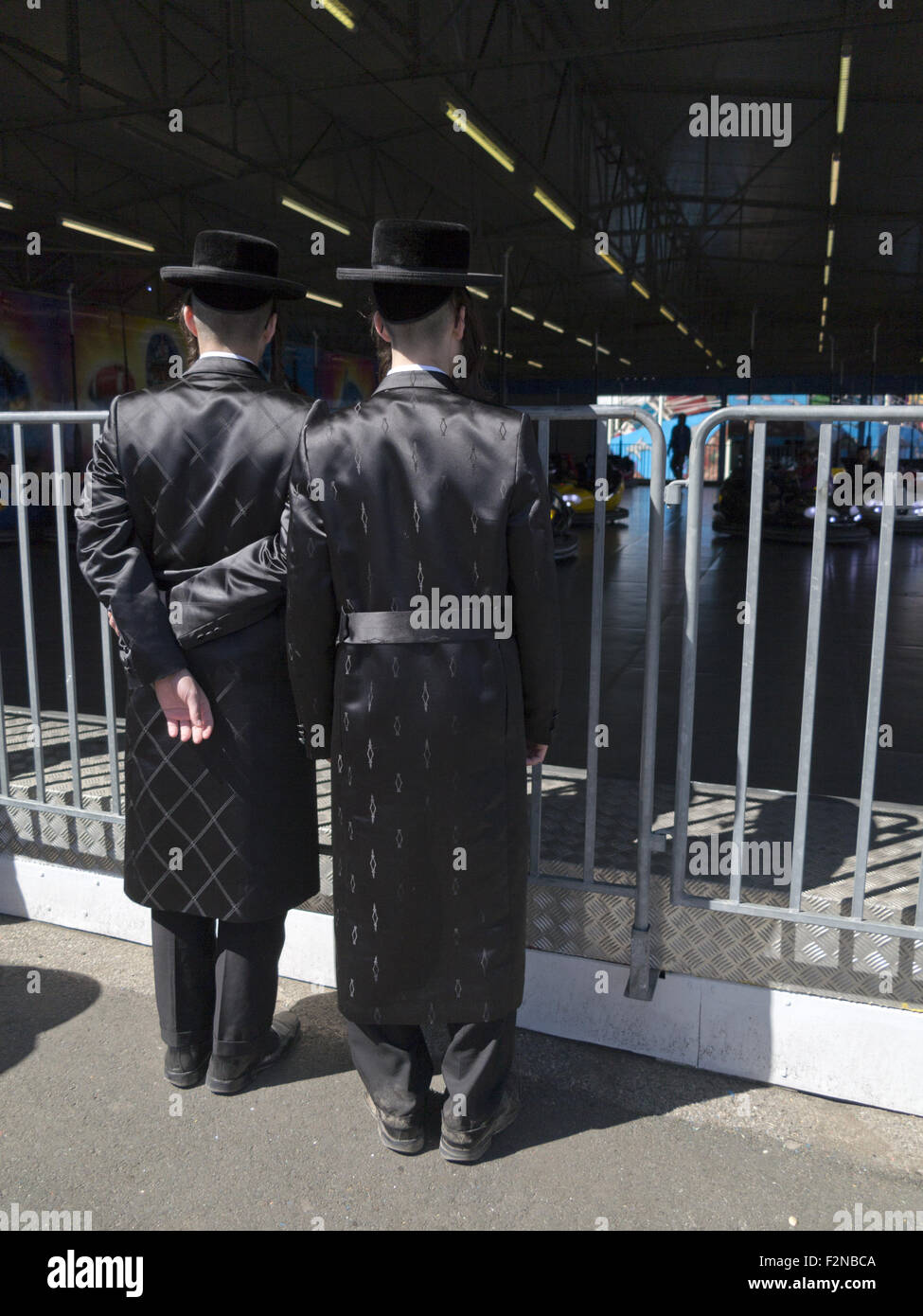 Giovani uomini Hasidic guardare il paraurti di automobili a Coney Island a Brooklyn, New York. Foto Stock