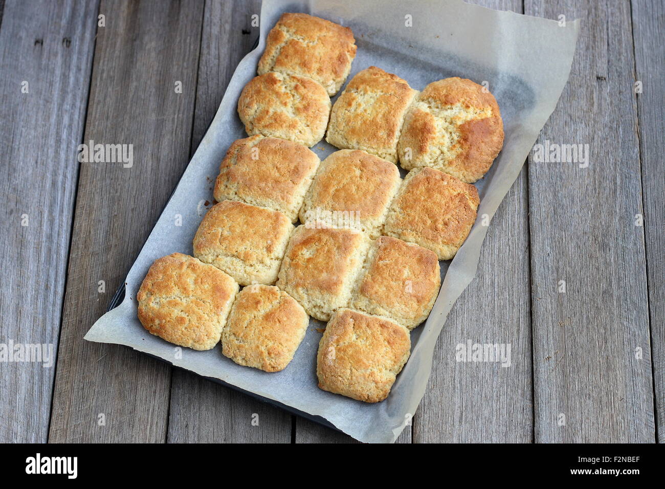 Pane appena sfornato focaccine fatte in casa in una teglia da forno su una tavola di legno Foto Stock