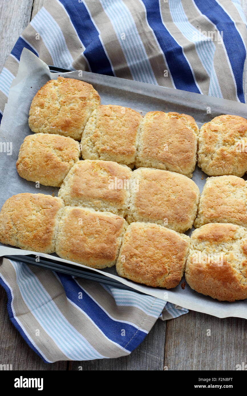 Pane appena sfornato focaccine fatte in casa in una teglia da forno su una tavola di legno Foto Stock