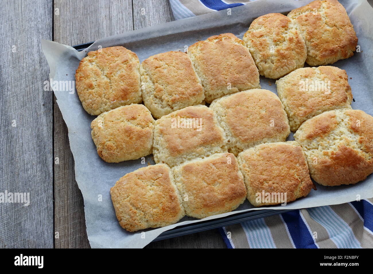 Pane appena sfornato focaccine fatte in casa in una teglia da forno su una tavola di legno Foto Stock