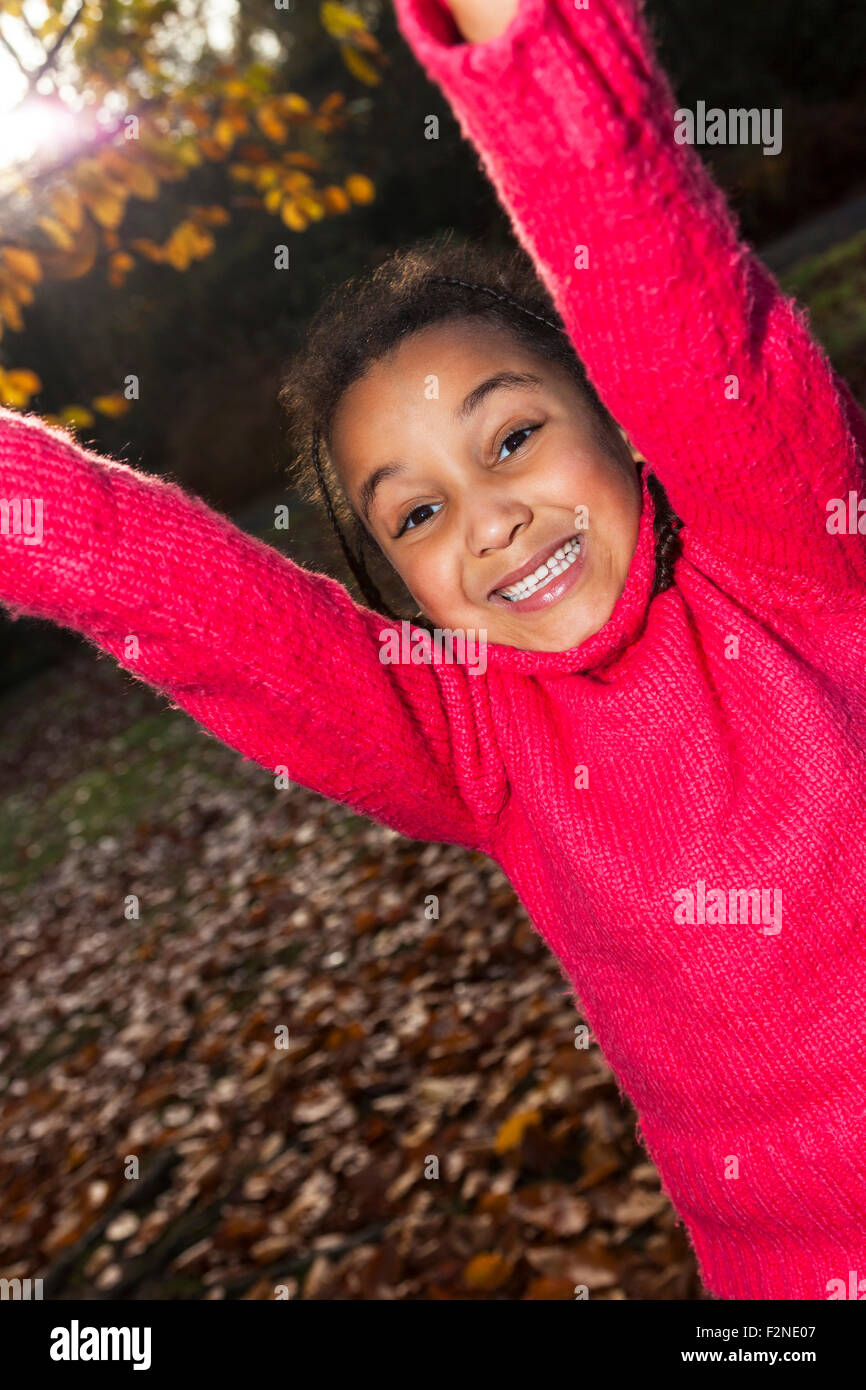 Fotografia ritratto di una giovane e bella sorridendo felice razza mista interracial African American Girl, giocare al di fuori in un parco Foto Stock