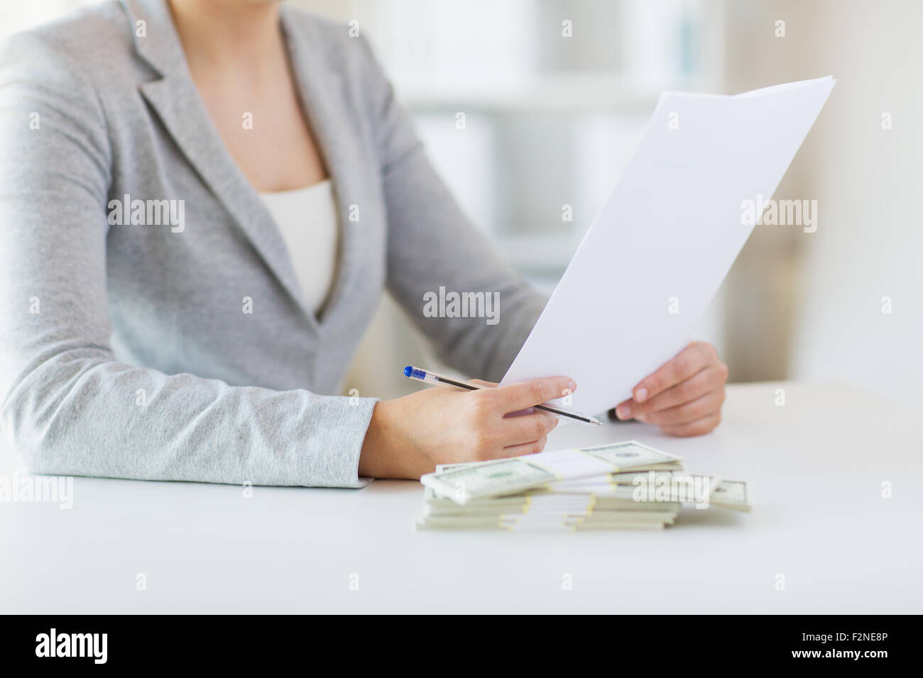 Close up di mani femminili con il denaro e la relazione fiscale Foto Stock