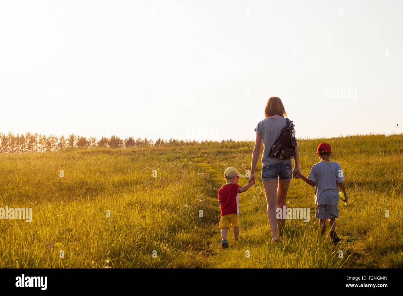 Madre e figli a piedi in campo rurale Foto Stock