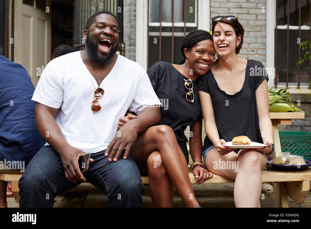 Gli amici di ridere a backyard barbecue Foto Stock