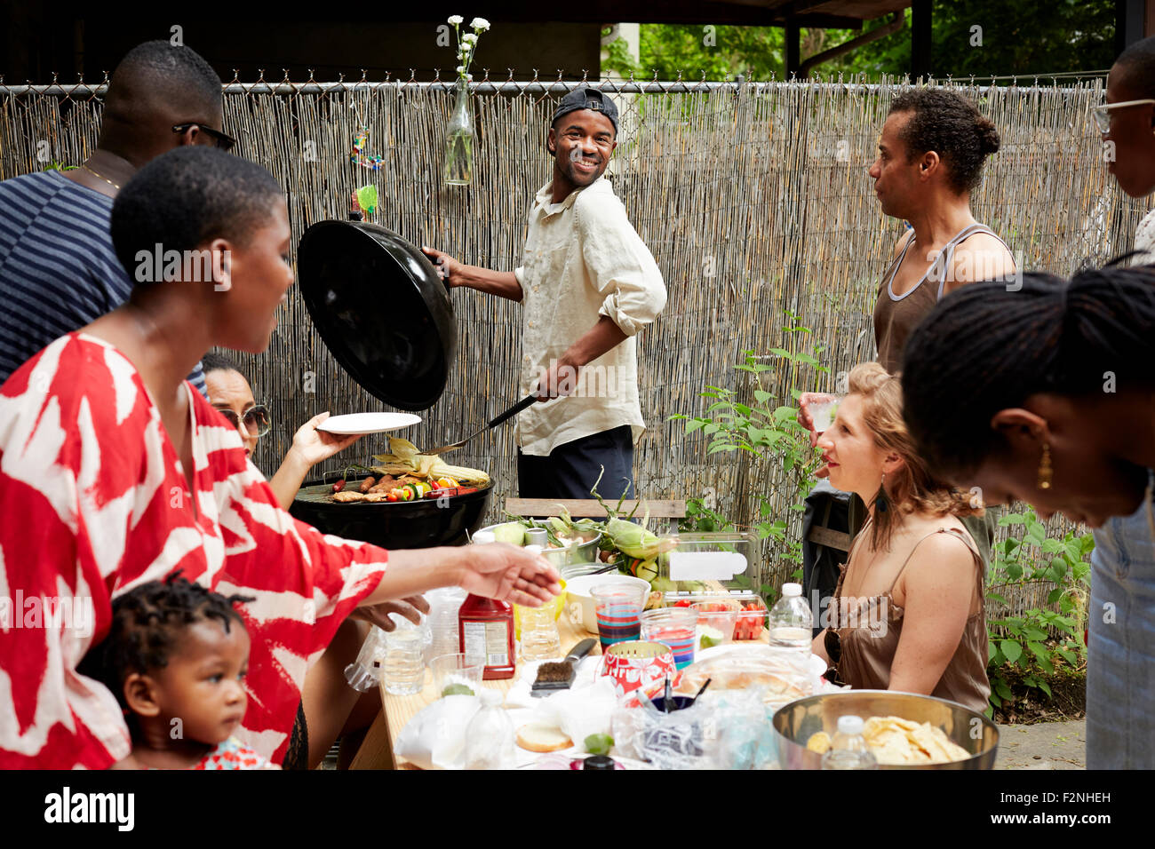 Gli amici sorseggiando backyard barbecue Foto Stock