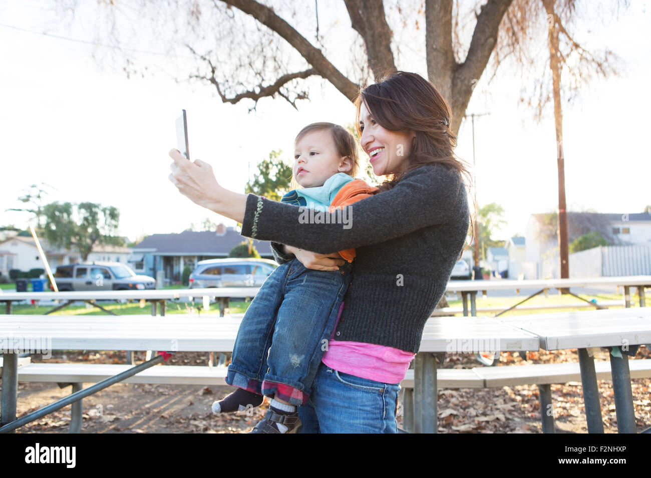 Madre ispanica tenendo selfie con figlio in posizione di parcheggio Foto Stock