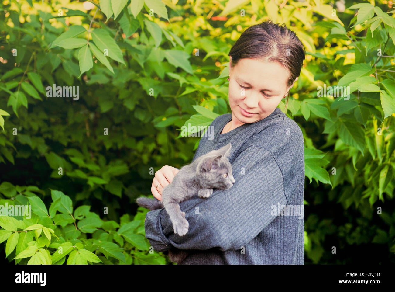 La donna caucasica petting cat in giardino Foto Stock