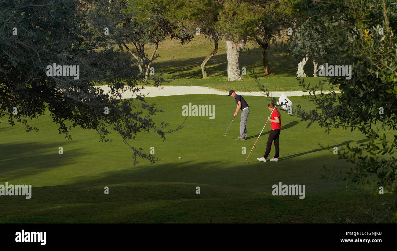 Coppia caucasica mettendo sul campo da golf Foto Stock