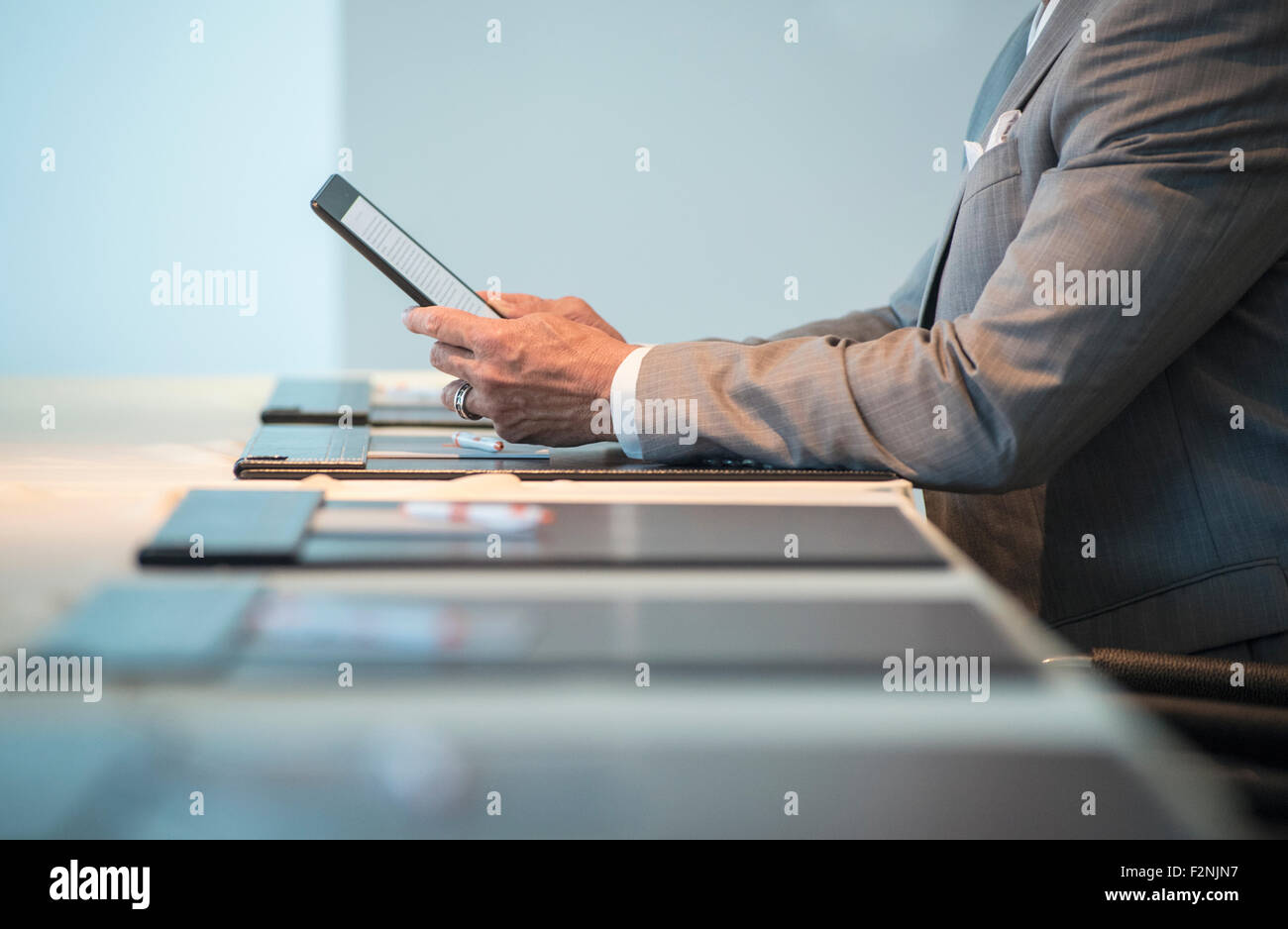 Imprenditore caucasico utilizzando tavoletta digitale a un tavolo per conferenza Foto Stock