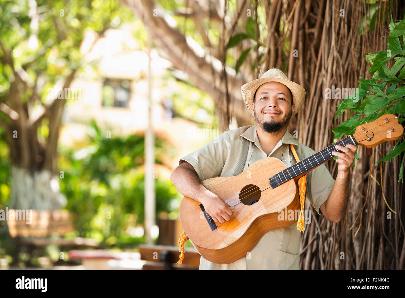 Musicista di origine ispanica a suonare la chitarra in posizione di parcheggio Foto Stock