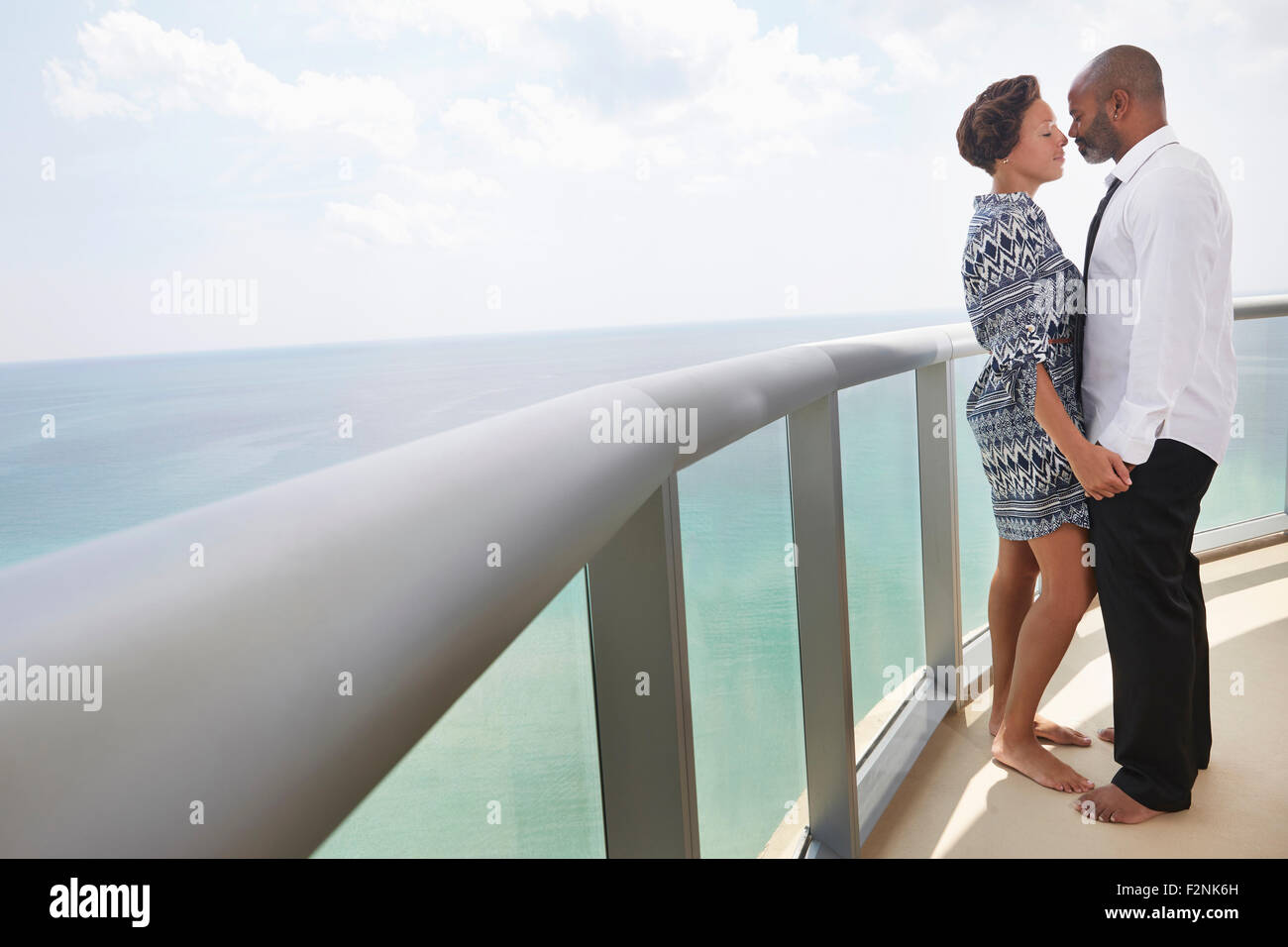 Coppia nero bacio sul balcone sull'oceano Foto Stock