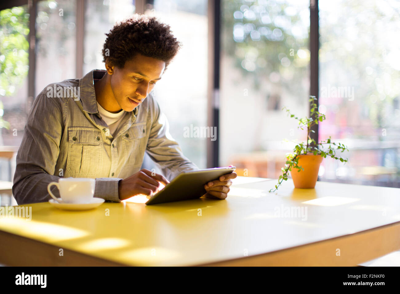 Razza mista uomo con tavoletta digitale in cafe Foto Stock