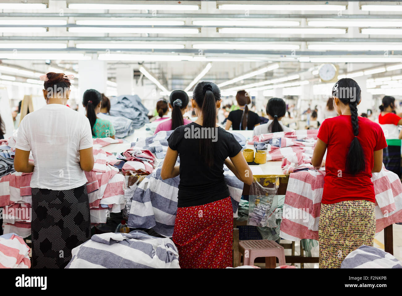 I lavoratori asiatici cucire vestiti in fabbrica di indumento Foto Stock