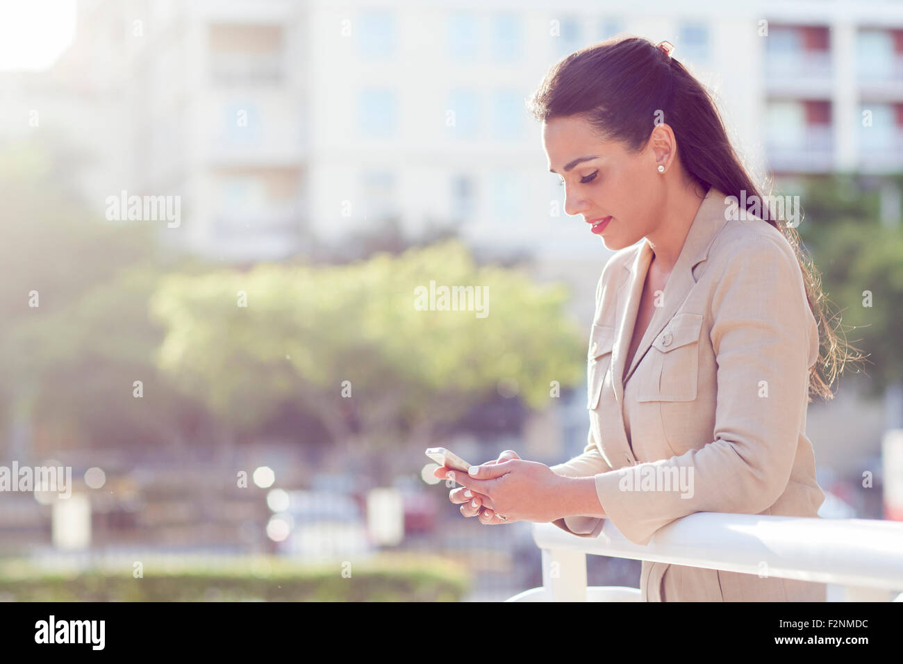 Imprenditrice ispanica tramite telefono cellulare all'aperto Foto Stock