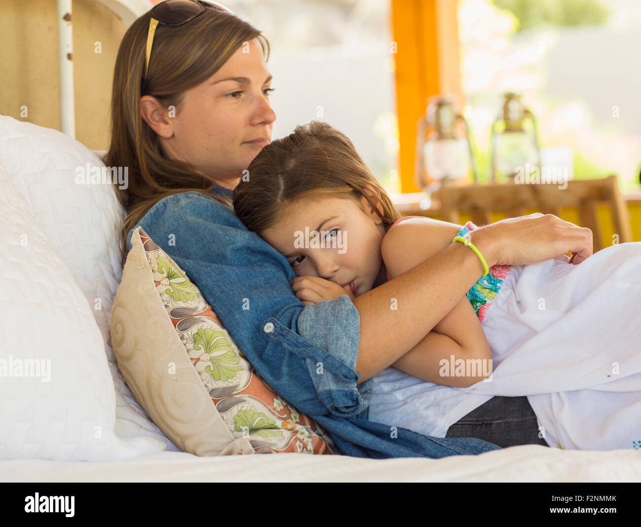 Madre consolante triste figlia sul letto Foto Stock