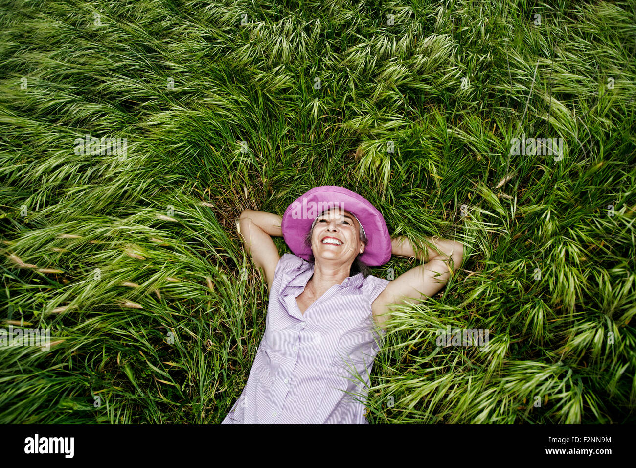 La donna caucasica posa in erba alta Foto Stock