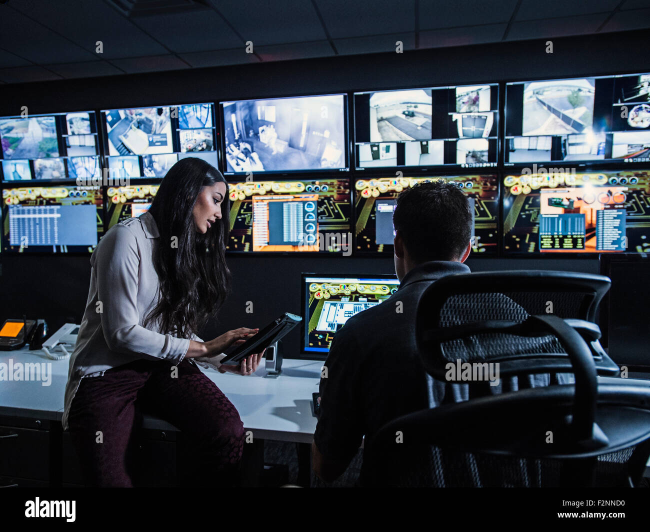 Le guardie di sicurezza a guardare i monitor in sala di controllo Foto Stock