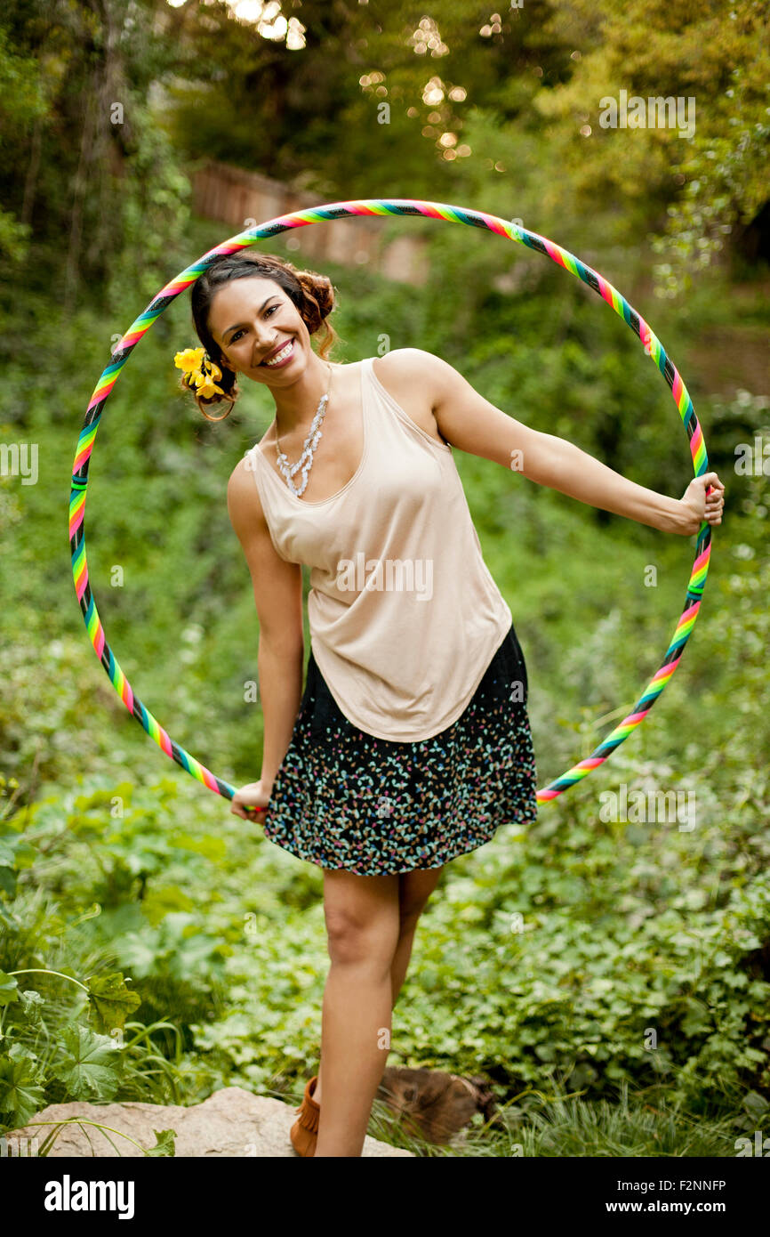 Razza mista donna che gioca con il cerchio in plastica Foto Stock